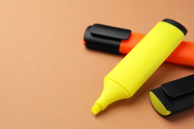 Photo of Bright color markers on pale orange background, closeup. Space for text