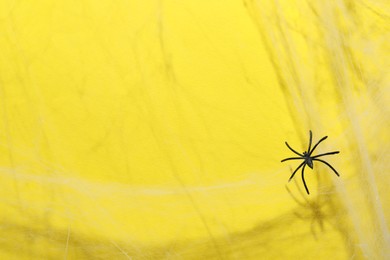 Cobweb and spider on yellow background, space for text