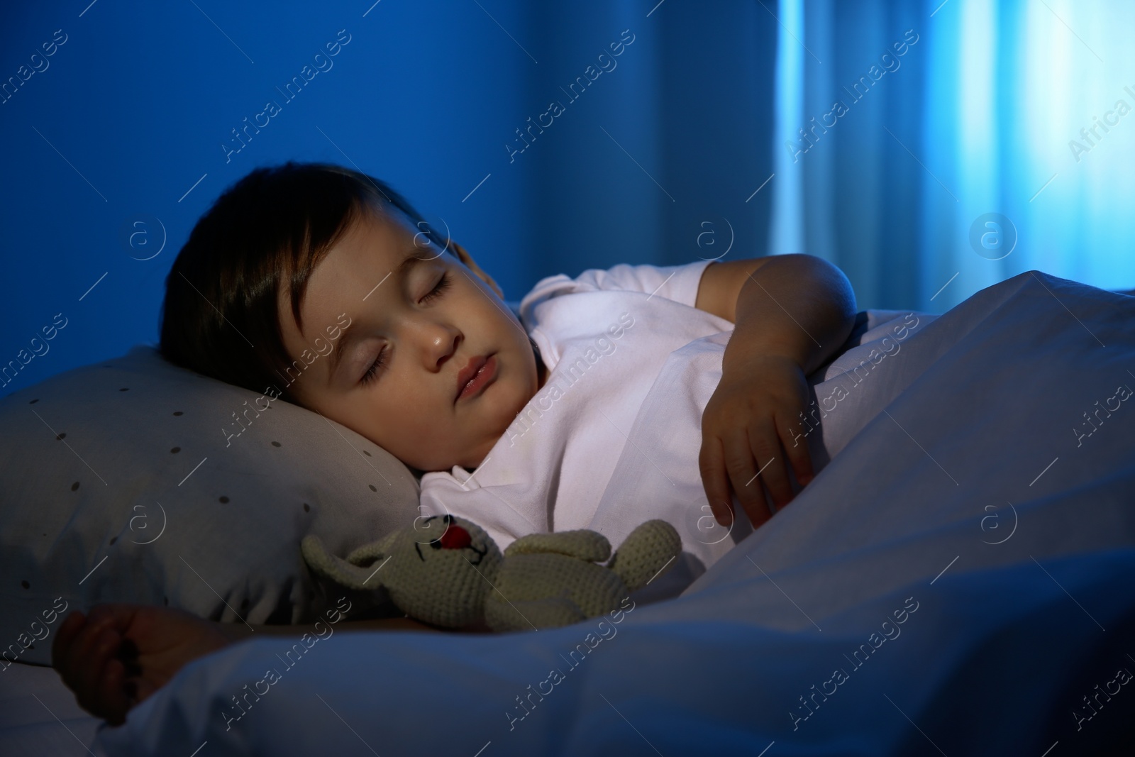 Photo of Cute little baby sleeping with toy at home. Bedtime