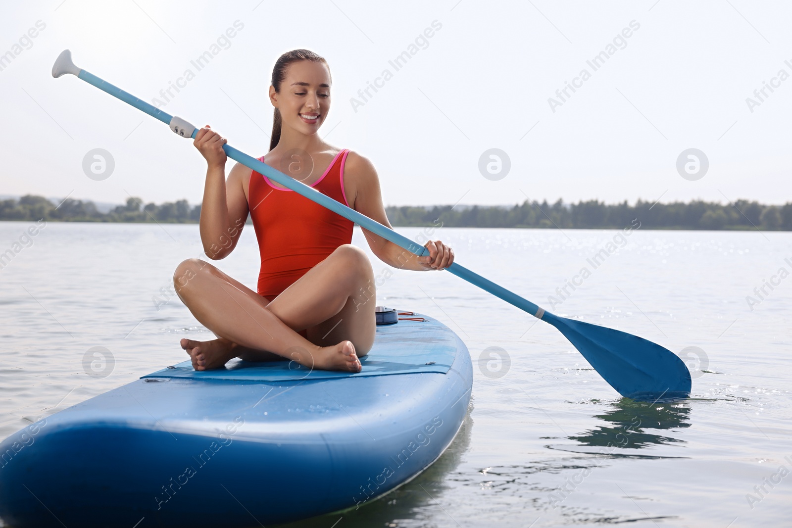 Photo of Woman paddle boarding on SUP board in sea, space for text