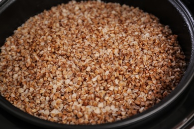 Photo of Delicious hot buckwheat in modern multi cooker, closeup