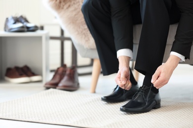 Photo of Young man trying on shoes in store