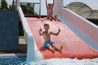 Photo of Cute little children on slide in water park