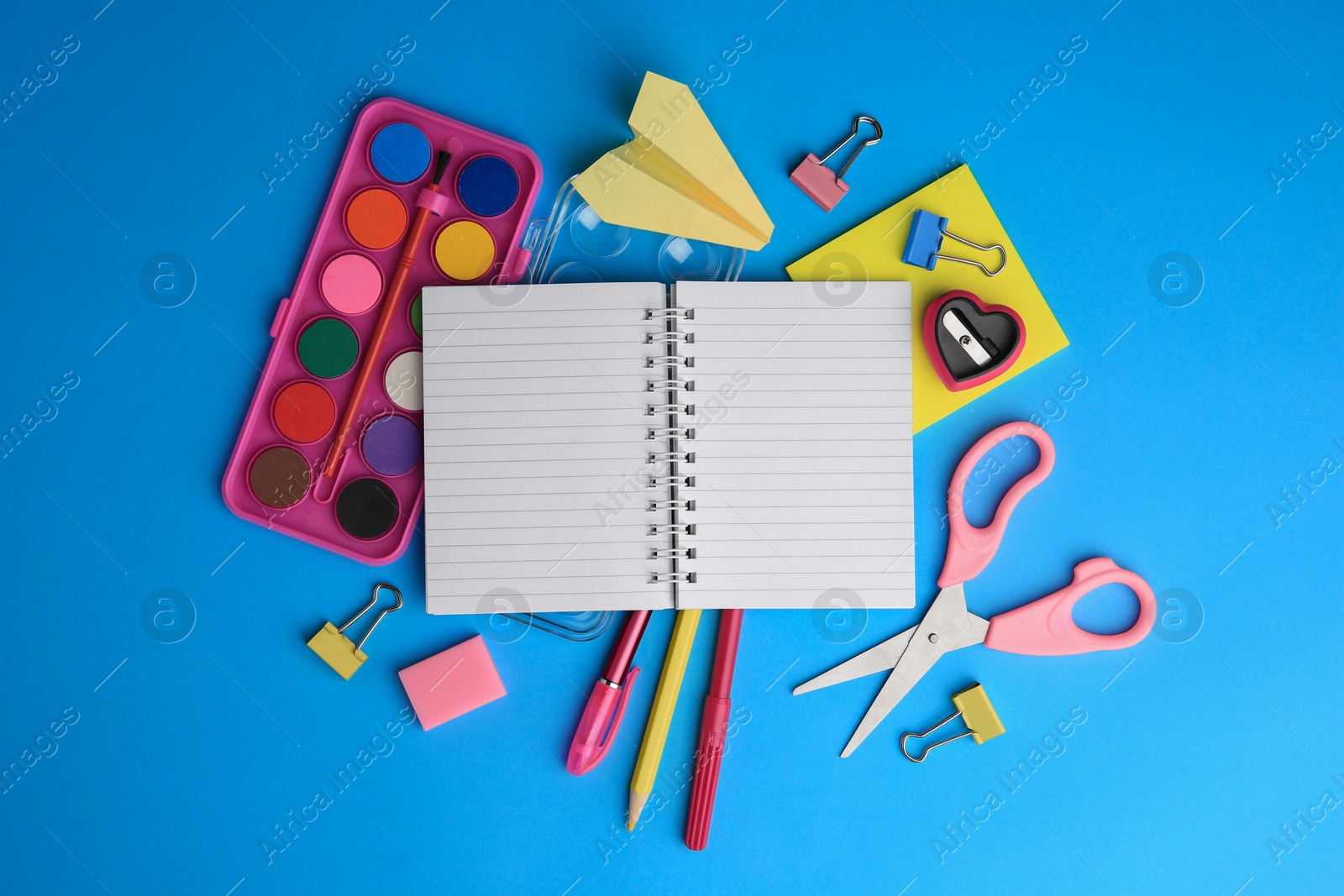 Photo of Flat lay composition with blank notebook and other school stationery on light blue background, space for text. Back to school