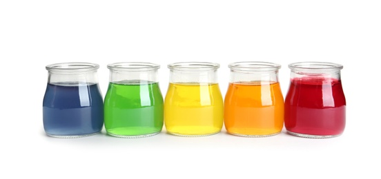 Photo of Tasty jelly desserts in glass jars on white background