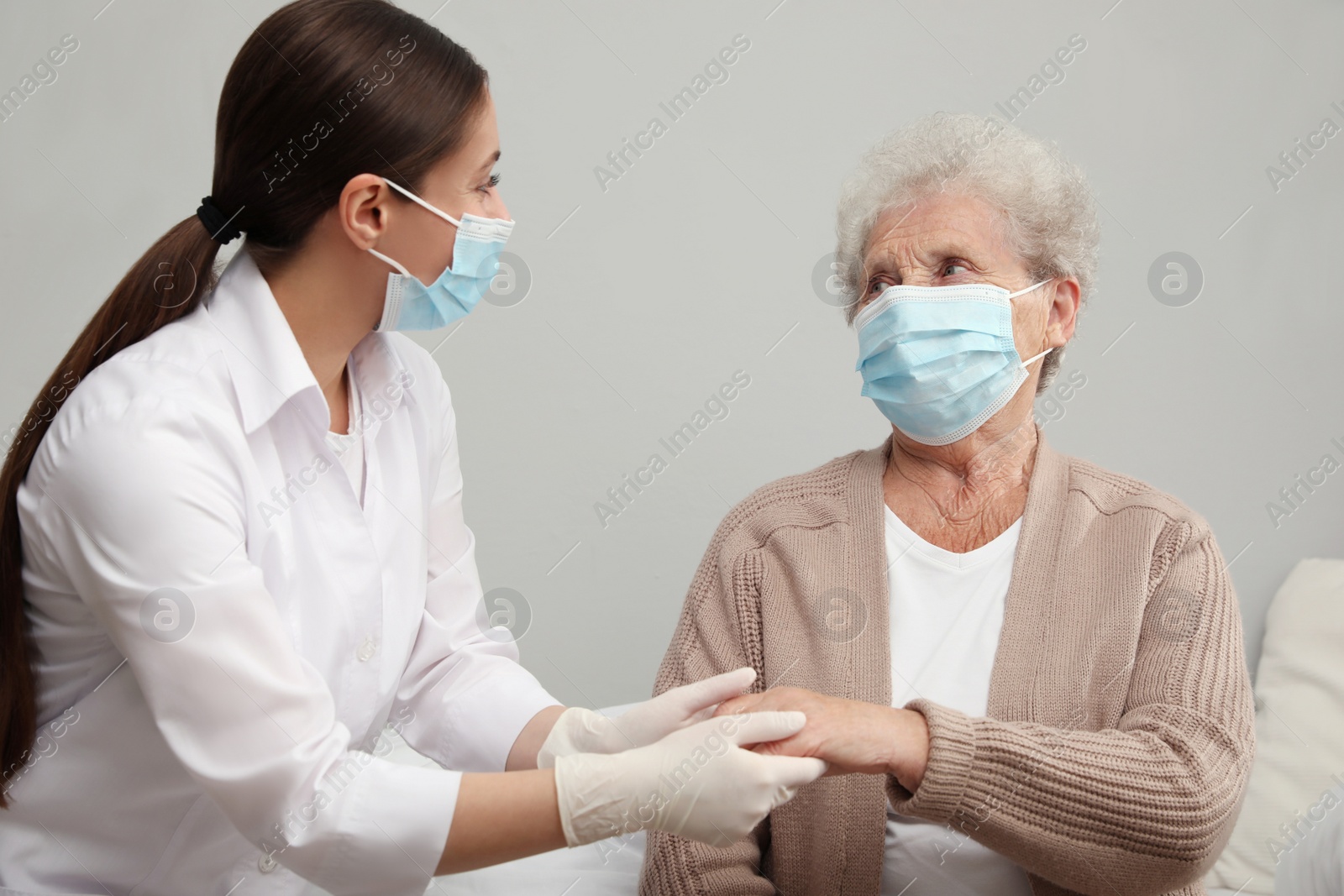 Photo of Doctor taking care of senior woman with protective mask at nursing home