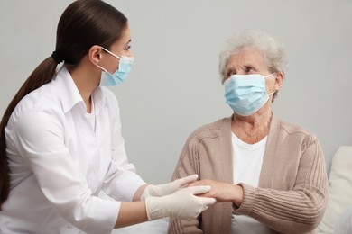 Photo of Doctor taking care of senior woman with protective mask at nursing home