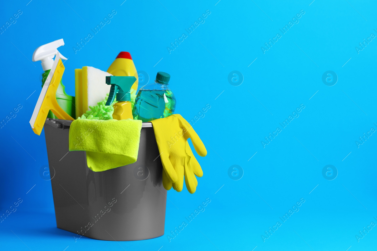 Photo of Different car products in bucket on light blue background