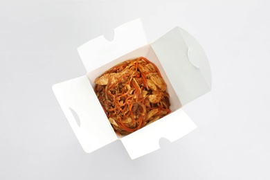 Photo of Chinese noodles in paper box, top view. Food delivery