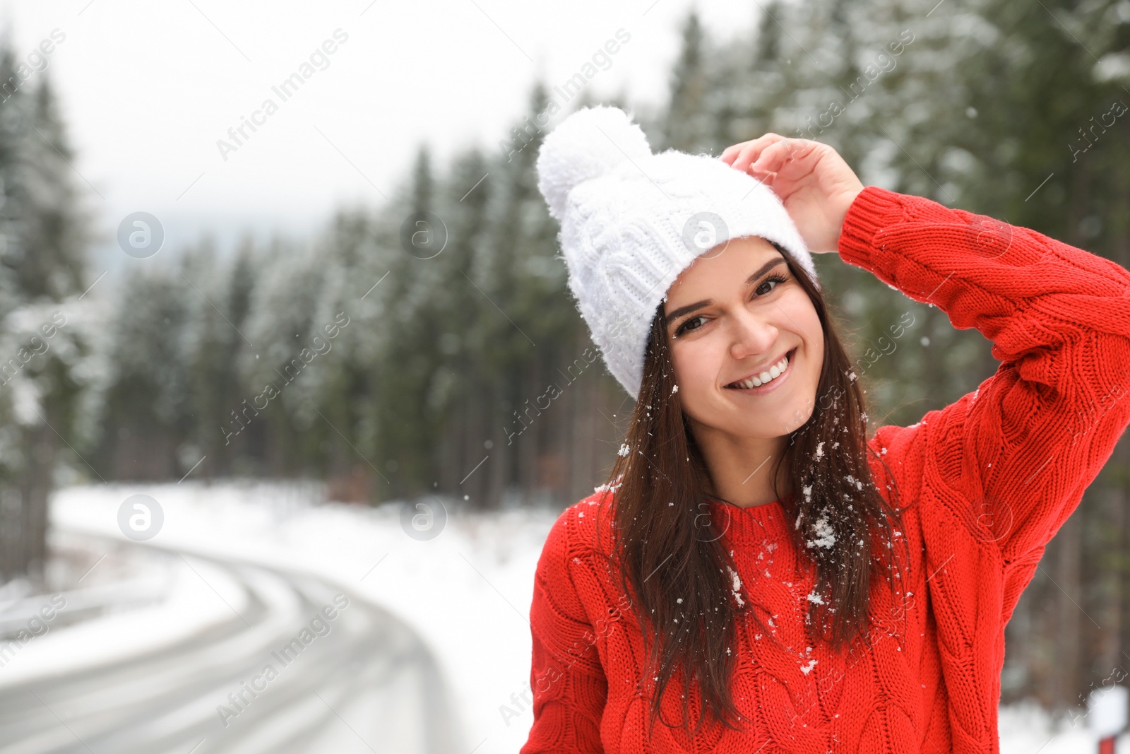 Photo of Young woman in warm sweater outdoors on snowy day, space for text. Winter vacation