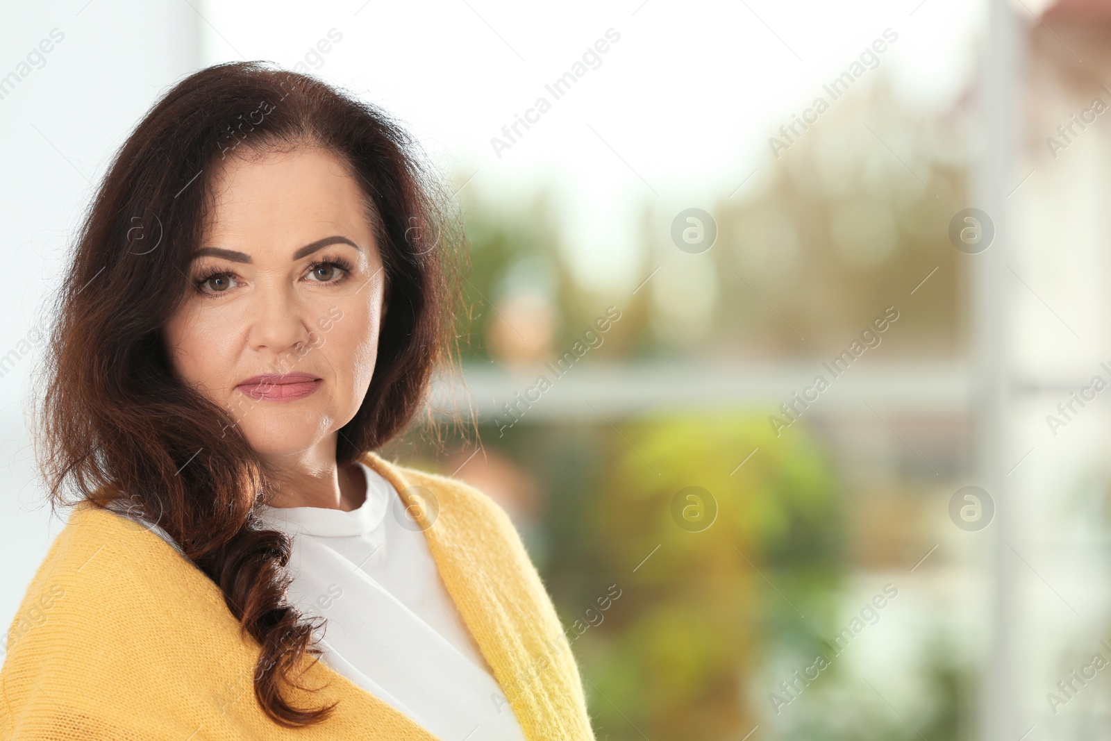 Photo of Portrait of beautiful older woman against blurred background with space for text