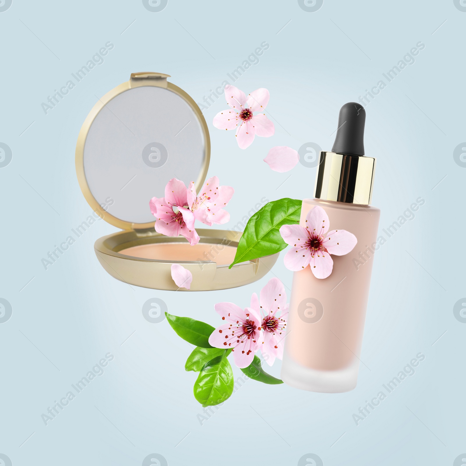 Image of Spring flowers and makeup products in air on light blue background