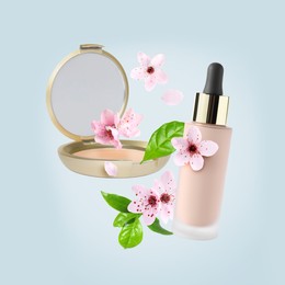 Image of Spring flowers and makeup products in air on light blue background