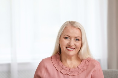 Photo of Portrait of beautiful older woman against blurred background