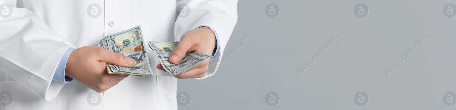 Image of Doctor with bribe on grey background, closeup. Banner design