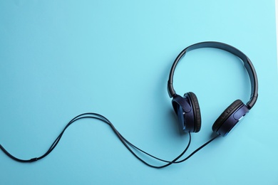 Photo of Stylish headphones on color background, top view. Space for text