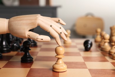 Robot moving chess piece on board, closeup. Wooden hand representing artificial intelligence