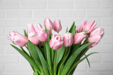 Beautiful pink spring tulips on white brick background