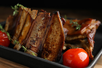 Photo of Delicious roasted ribs served in pan, closeup