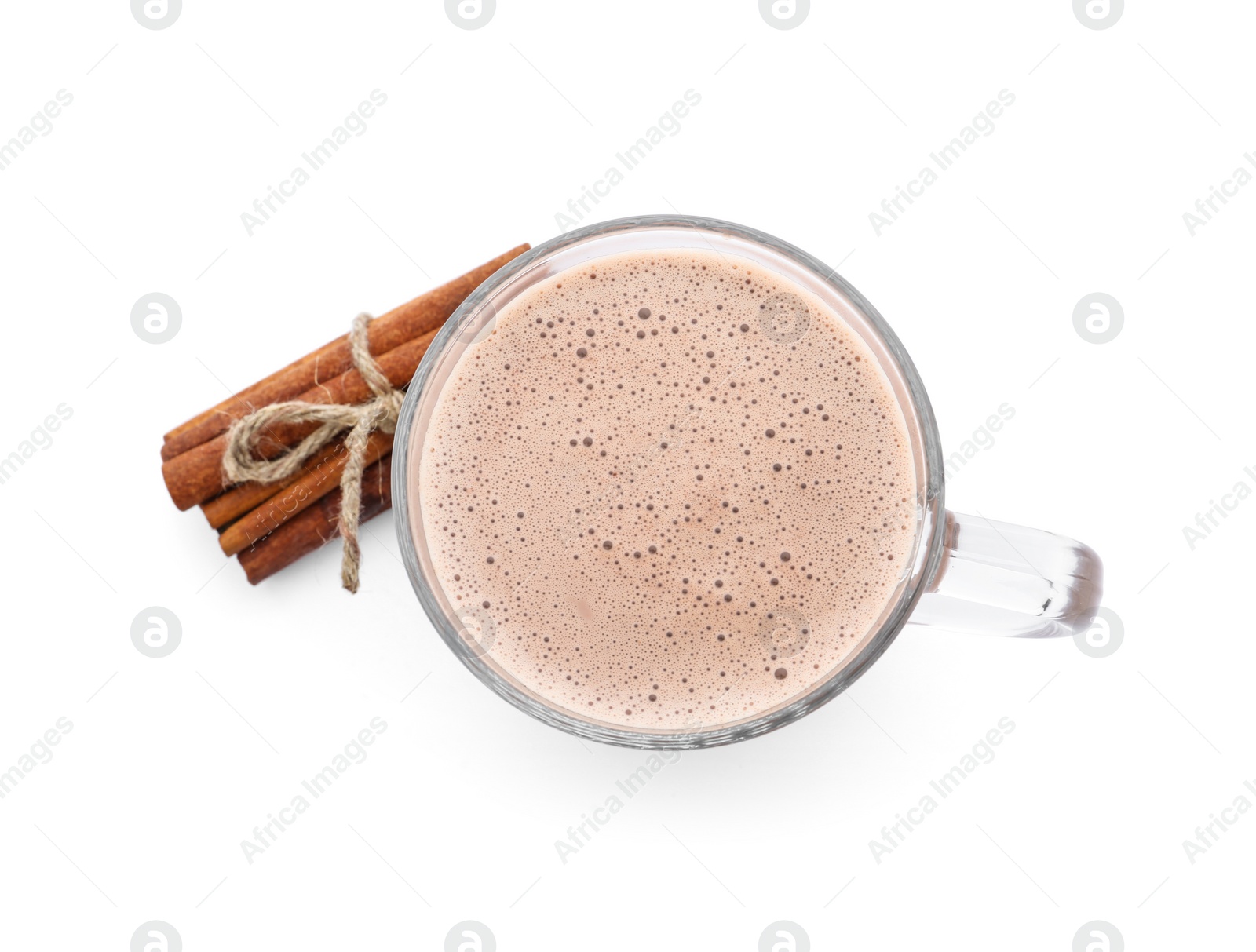 Photo of Delicious cocoa drink in glass cup and cinnamon sticks on white background, top view