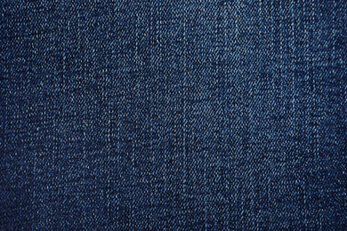 Photo of Texture of dark blue jeans as background, closeup