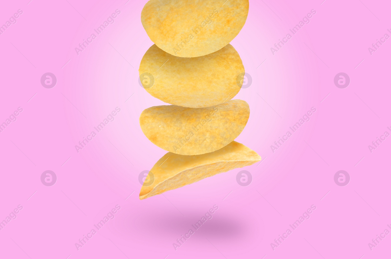 Image of Stack of tasty potato chips falling on light violet background