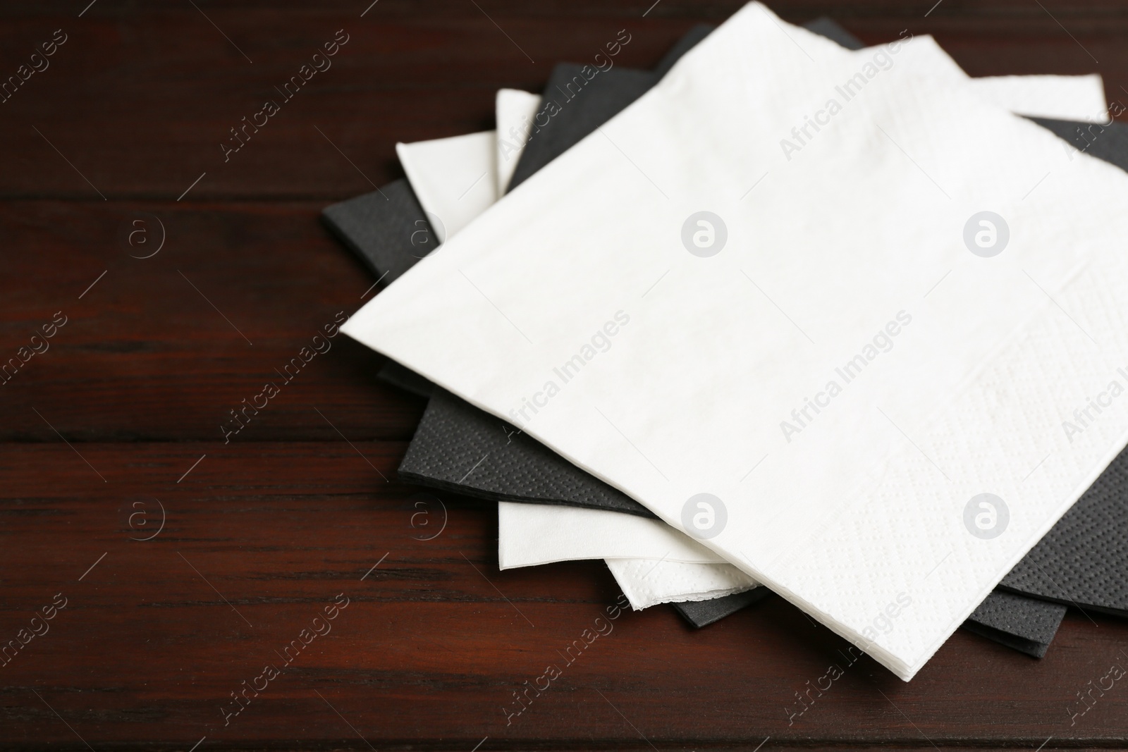 Photo of Clean napkins on wooden table, closeup. Personal hygiene