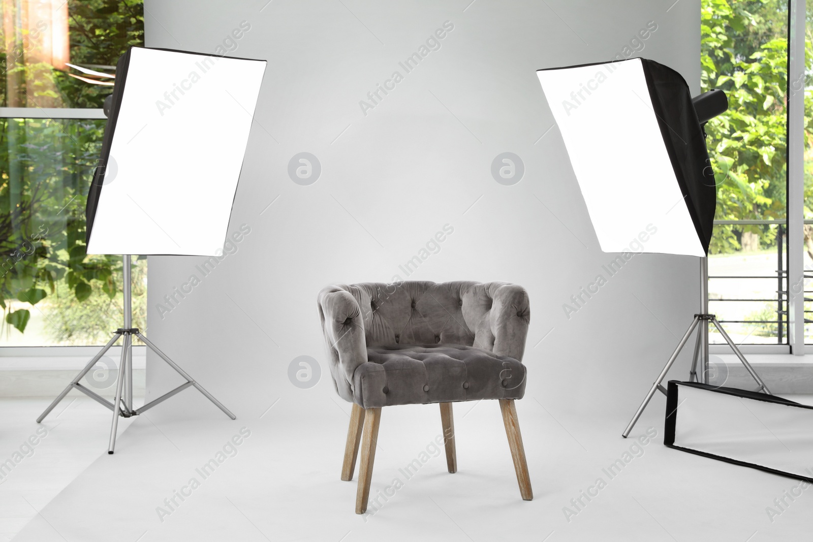 Photo of Interior of modern photo studio with armchair and professional equipment