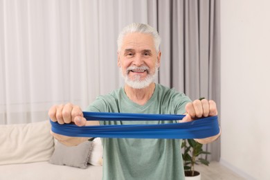 Senior man doing exercise with fitness elastic band at home