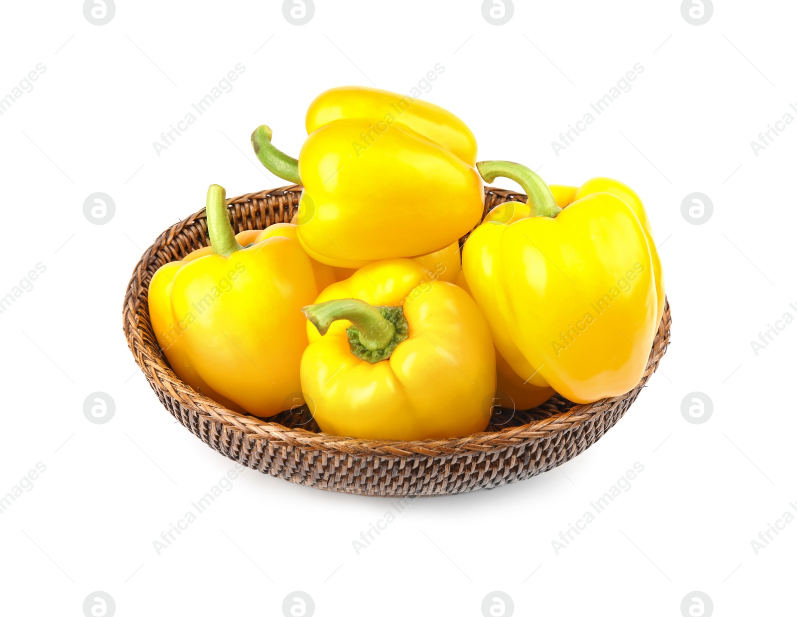 Photo of Wicker bowl of ripe yellow bell peppers isolated on white