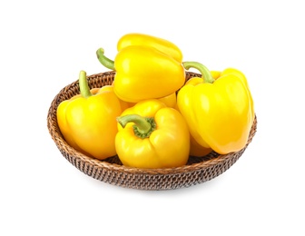 Photo of Wicker bowl of ripe yellow bell peppers isolated on white