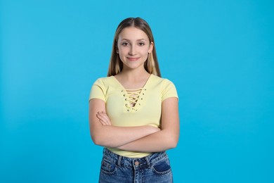 Portrait of beautiful teenage girl on light blue background