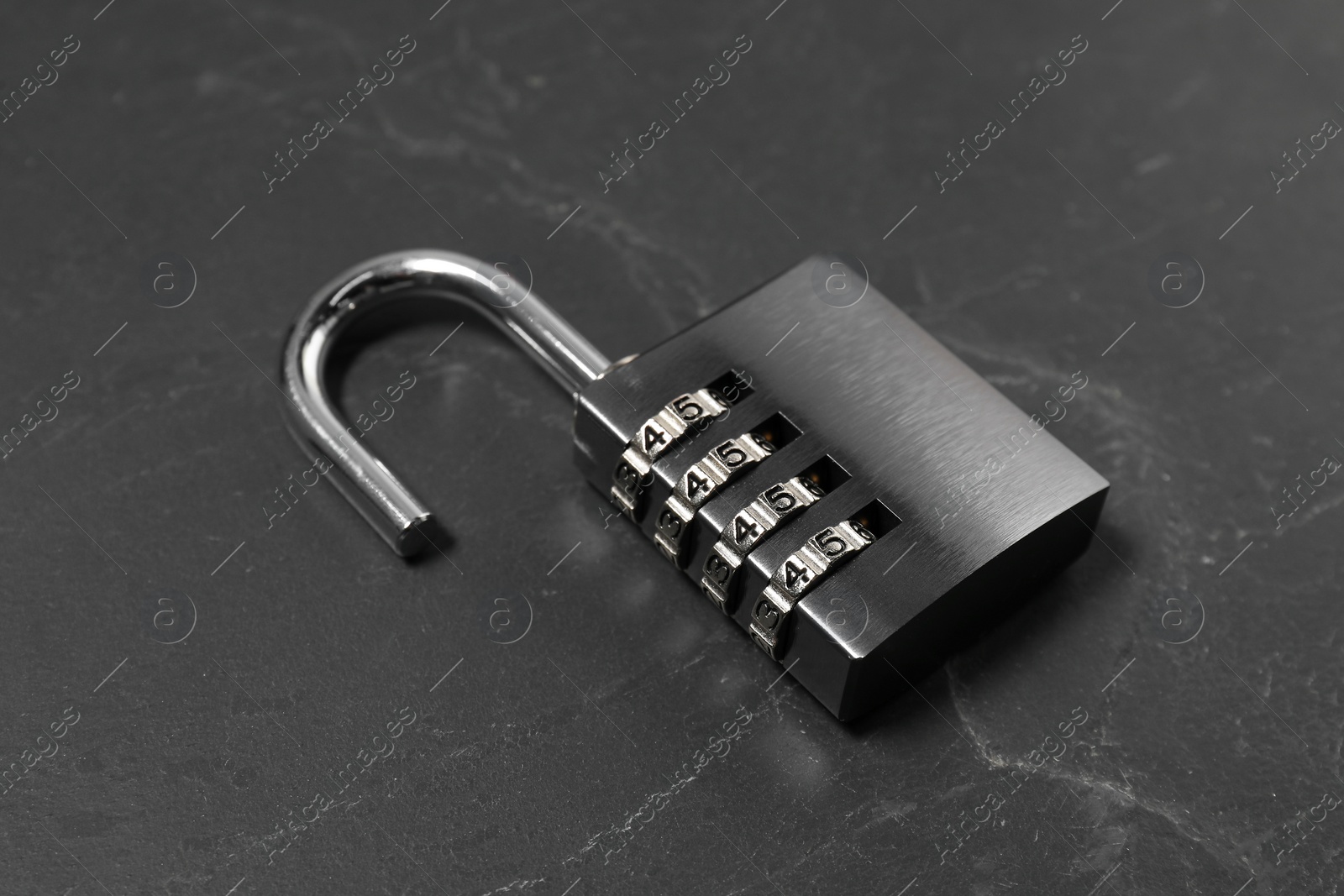 Photo of One steel combination padlock on black table, closeup