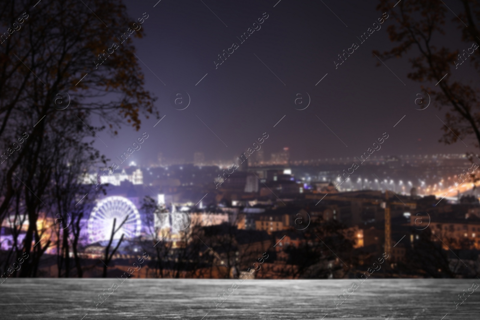 Image of Empty stone surface and blurred view of night city