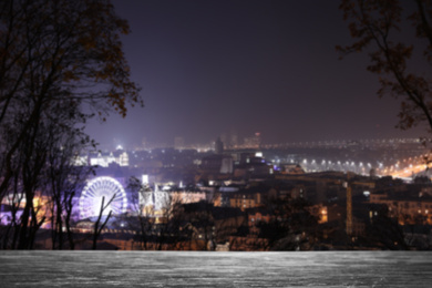 Image of Empty stone surface and blurred view of night city