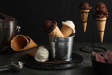 Photo of Ice cream scoops in wafer cones on gray textured table