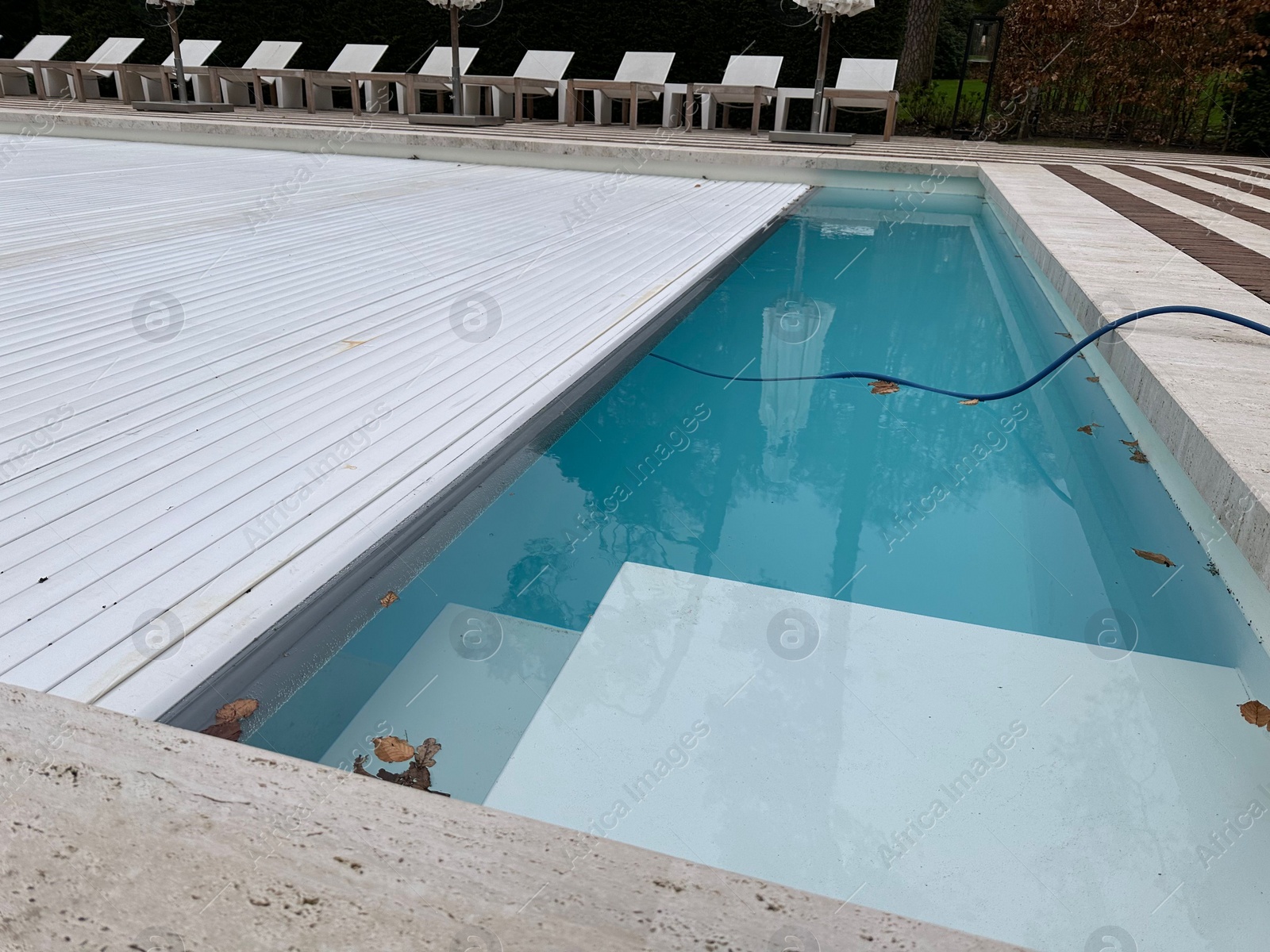 Photo of Outdoor swimming pool with cover and fallen leaves