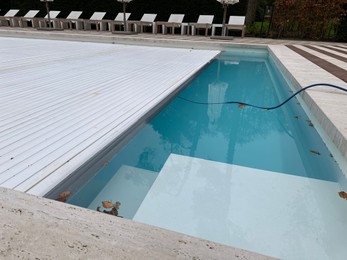 Photo of Outdoor swimming pool with cover and fallen leaves