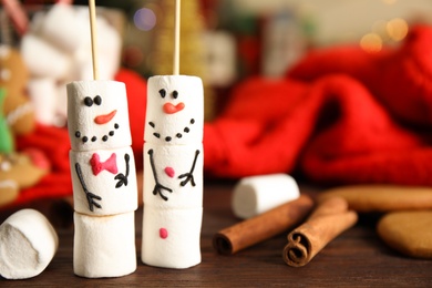 Funny snowmen made of marshmallows on wooden table, closeup. Space for text