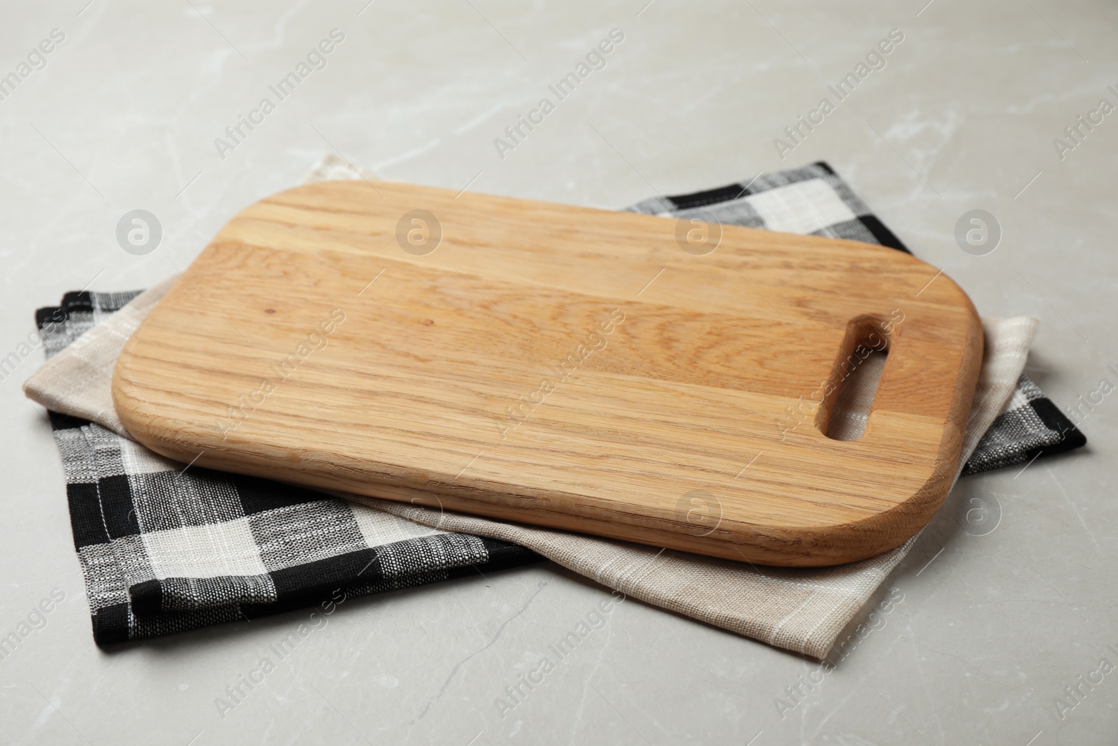 Photo of Wooden board and colorful kitchen towels on grey stone table