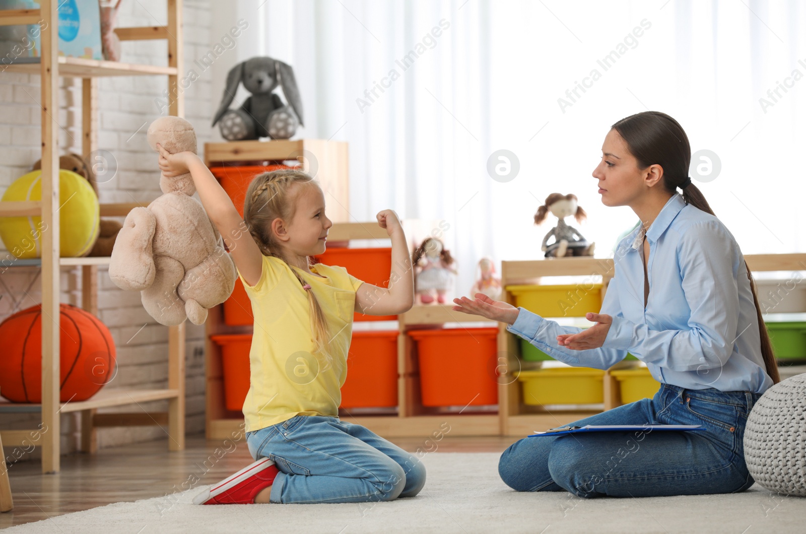 Photo of Child psychotherapist working with little girl in office