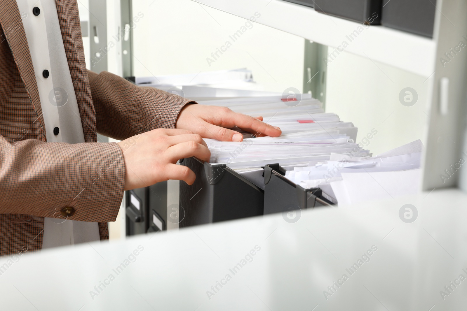 Photo of Woman taking documents from folder in archive, closeup