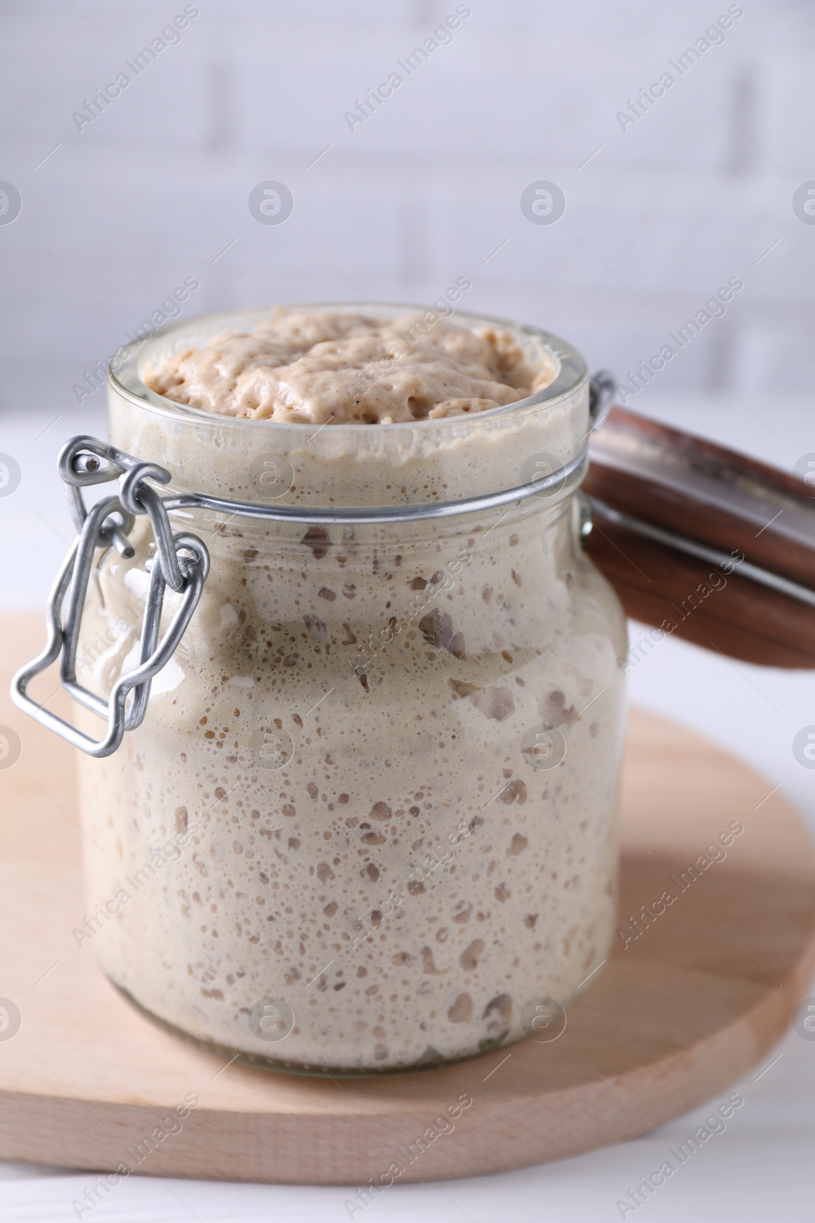 Photo of Sourdough starter in glass jar on table