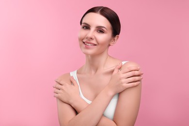 Photo of Beautiful woman with healthy skin on pink background. Body Care