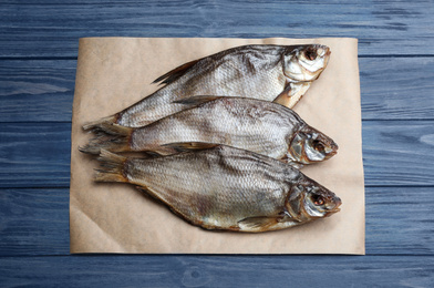 Photo of Tasty dried fish on blue wooden table, top view