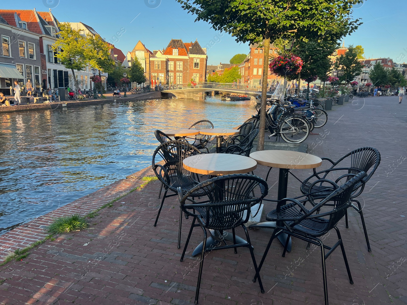 Photo of Leiden, Netherlands - August 1, 2022: Picturesque view of city street with cafe and beautiful buildings along canal