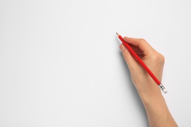 Woman with new graphite pencil on white background, top view. Space for text