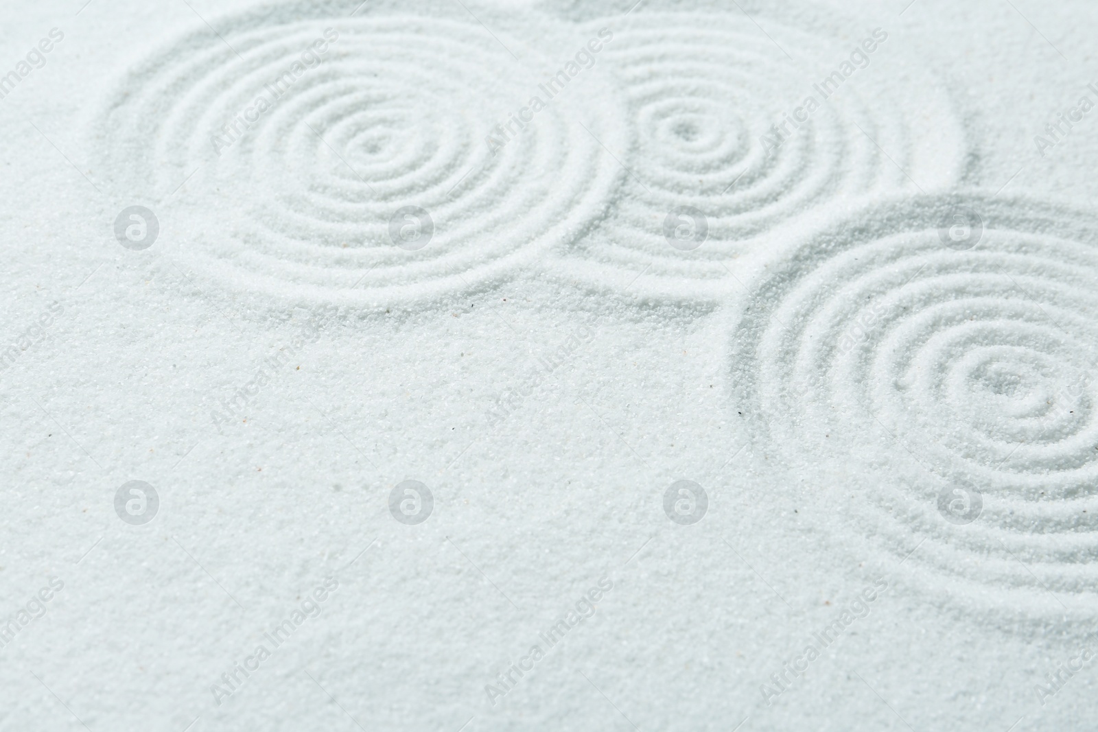 Photo of Zen rock garden. Circle patterns on white sand, closeup. Space for text