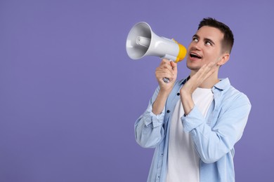 Special promotion. Young man shouting in megaphone on violet background, space for text