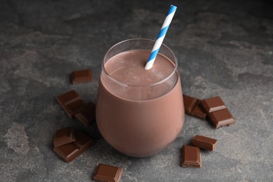 Photo of Delicious chocolate milk in glass on grey table